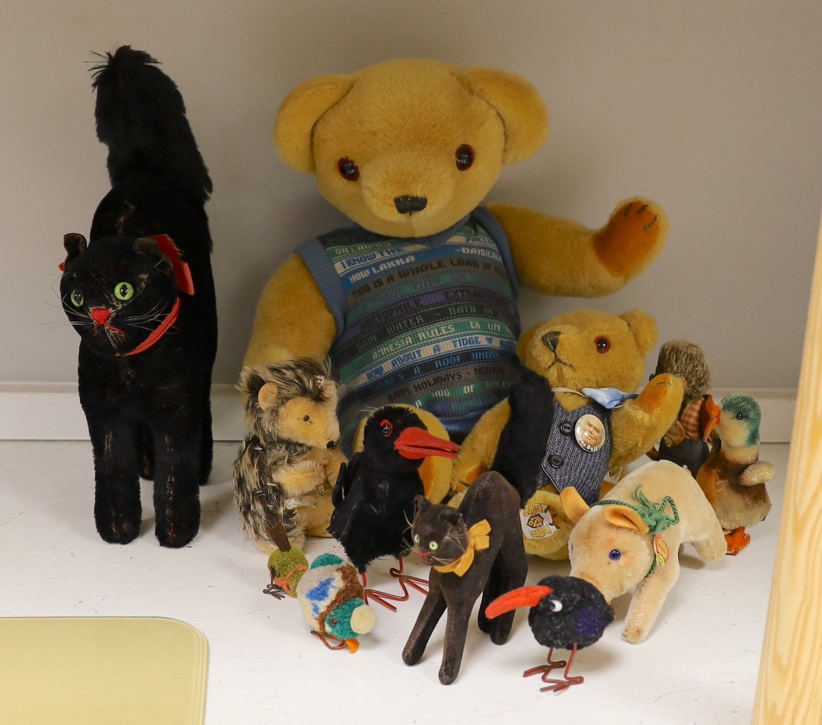 A collection of toys - a small black cat, a large black cat, a small pig, a hedgehog, a Macki hedgehog, two crows, a duck, two small birds with wire feet and two Peter Bull bears with pedigree certs. (12)